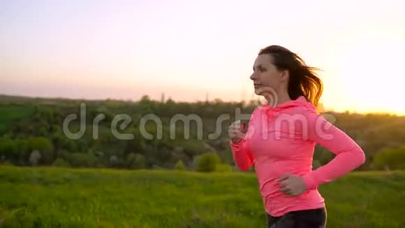 日落时分女人在户外跑慢动作视频的预览图