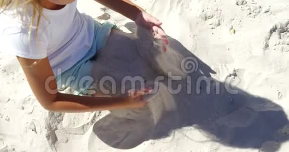 女孩在海滩上玩沙子视频的预览图