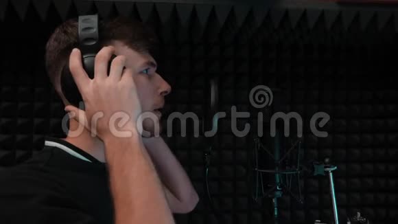年轻英俊的声乐艺术家在黑色背景的家庭音乐工作室唱歌流行男歌手录音声音专业人员视频的预览图