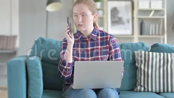 女人在打电话在手提电脑上工作视频的预览图