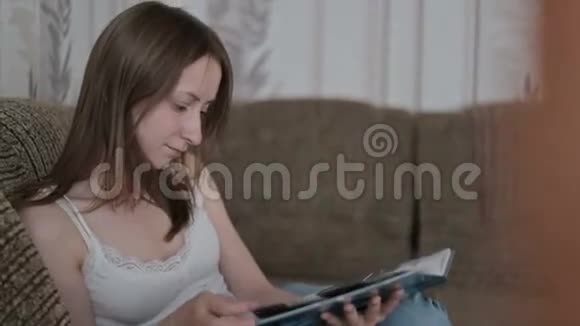 年轻女子在沙发上看书视频的预览图
