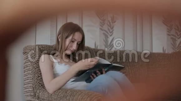 年轻女子在沙发上看书视频的预览图