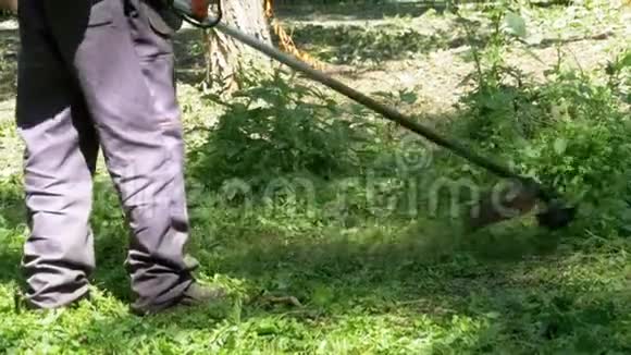 男子用便携式割草机割草慢动作视频的预览图