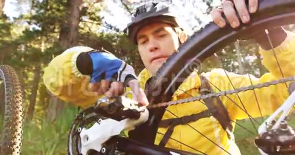 男山地骑自行车的人修理他的自行车视频的预览图