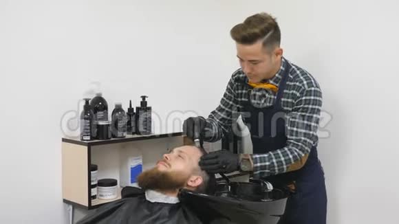 男士美容师理发店照顾胡子理发师为留胡子的人做发型视频的预览图