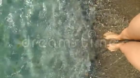 女人的腿站在蓝色的海水波浪中个人视野慢动作视频的预览图