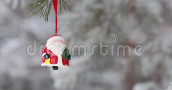 新年圣诞节和装饰品玩具圣诞老人在森林里的树枝上摇摆下雪视频的预览图