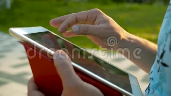 男性手滚动平板电脑视频的预览图