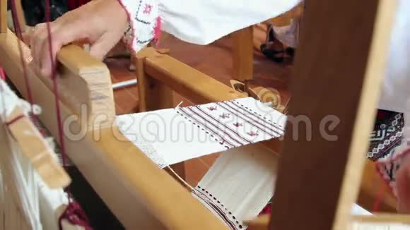 一个女人的手在一个古老的木织机上编织视频的预览图