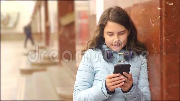 少女在地下地铁里坐地铁等待生活方式火车的到来手持智能手机视频的预览图