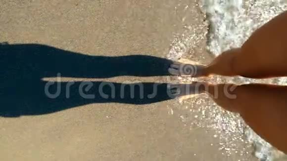 女人的腿站在蓝色的海水波浪中个人视野慢动作视频的预览图