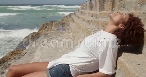 在阳光明媚的4k天气在海滩上放松的女人视频的预览图