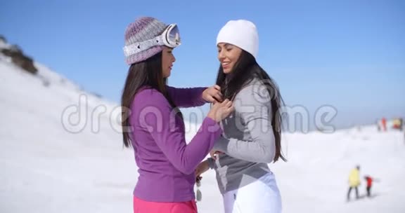 两个迷人的年轻女子在雪地里聊天视频的预览图