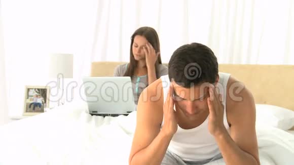 坐在床上头痛的男人视频的预览图