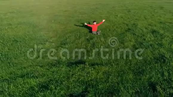低空径向飞行超过运动瑜伽男子在完美的绿草在山上日落视频的预览图