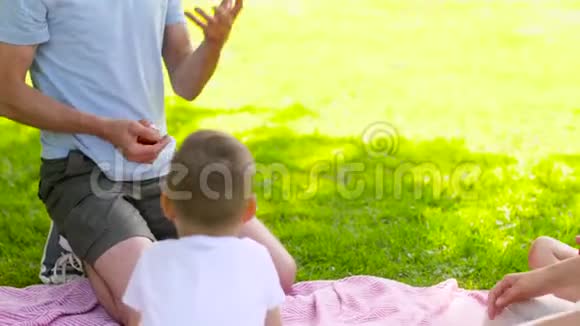 快乐的一家人在夏日公园野餐视频的预览图