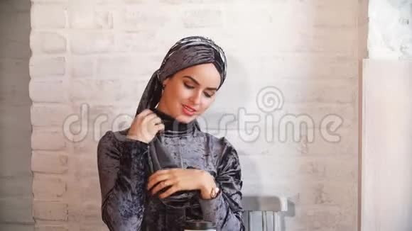 肖像美丽的穆斯林女孩戴着头巾看着镜头视频的预览图