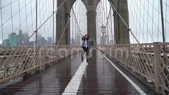 在布鲁克林大桥散步的年轻女子视频的预览图