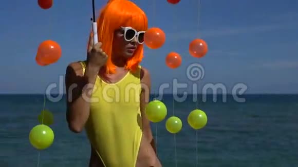 穿黄色泳衣和橙色假发的女人视频的预览图