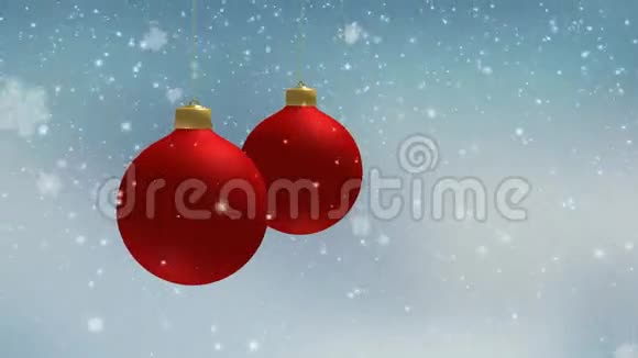 冬天模糊的圣诞节背景下着雪和挂着红色的圣诞装饰球球慢动作动画视频的预览图