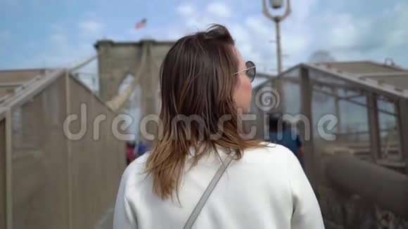 在布鲁克林大桥散步的年轻女子视频的预览图