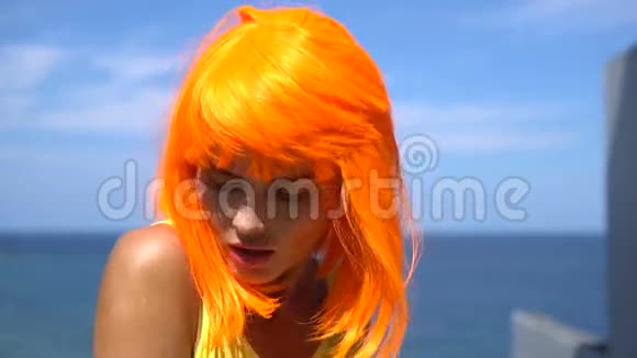 穿黄色泳衣和橙色假发的女人视频的预览图