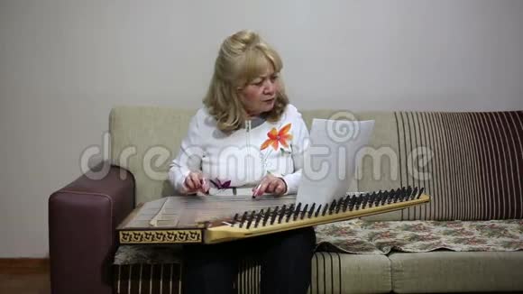 高级妇女演奏qanun乐器视频的预览图