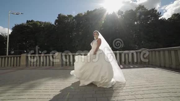 美丽可爱的新娘穿着婚纱戴着面纱慢动作视频的预览图