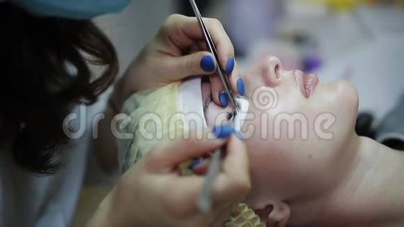 美容师为美丽的女孩增加睫毛延长睫毛手术视频的预览图