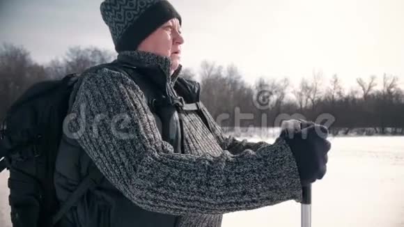 一位老年妇女在冬季森林里用木棍做北欧人的散步健康的生活方式观念成熟成熟视频的预览图