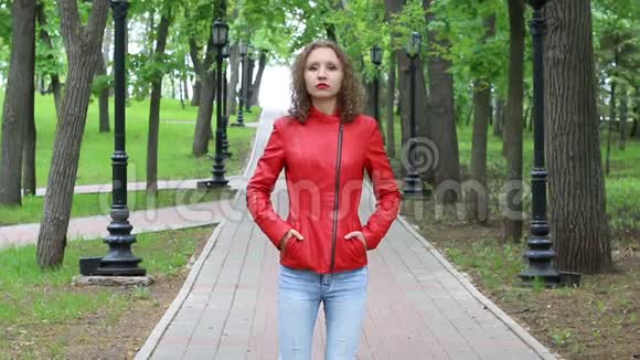 秋天公园穿红色皮夹克的漂亮女孩视频的预览图
