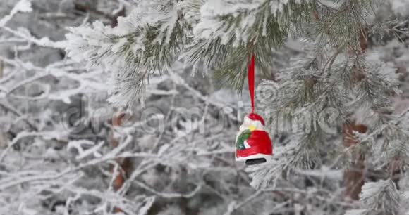 新年圣诞节和装饰品玩具圣诞老人在森林里的树枝上摇摆下雪视频的预览图