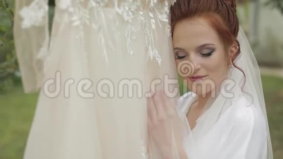 美丽可爱的新娘穿着睡衣和面纱结婚礼服慢动作视频的预览图