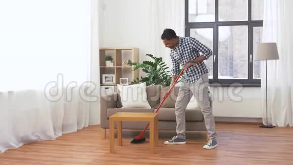 带扫把清洁地板的男人视频的预览图