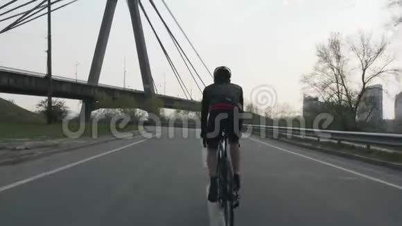适合三项运动员骑自行车与桥的背景参加铁人三项比赛的训练铁人三项的概念视频的预览图