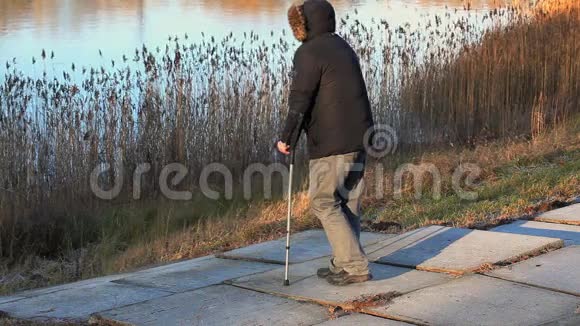 残疾人拄着拐杖在湖边视频的预览图