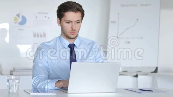 年轻的商人在笔记本电脑上工作视频的预览图