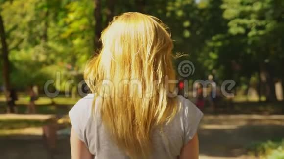 穿白色短裤的女孩在晴朗的晴天骑着赛格威夏天公园和阳光4k慢镜头拍摄视频的预览图