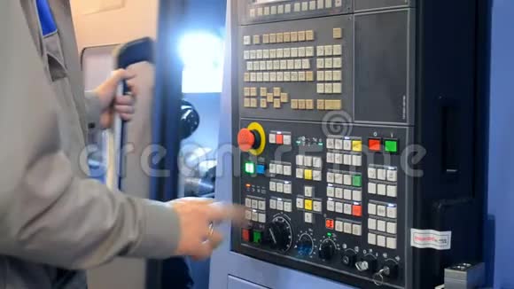 在控制面板上工作的人用工业机器工作视频的预览图
