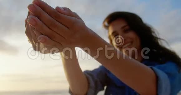 沙滩上玩沙子的女人4k视频的预览图