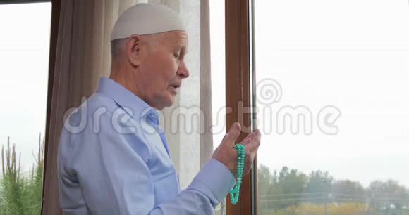 一位戴着念珠的老人在祈祷视频的预览图