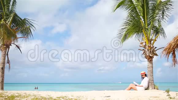 年轻女子在白沙滩读书视频的预览图