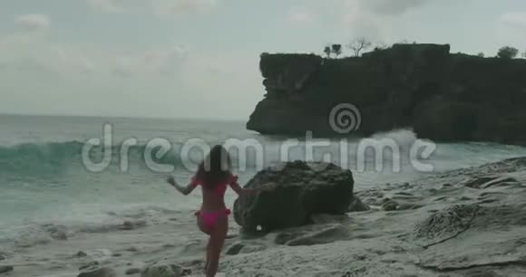 海滩上穿粉色比基尼的美女视频的预览图