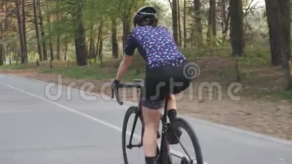 在公园里骑自行车的积极运动的女自行车运动员自行车训练骑自行车慢动作视频的预览图