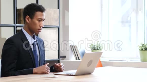 在笔记本电脑工作时黑人商人因损失而心烦意乱视频的预览图