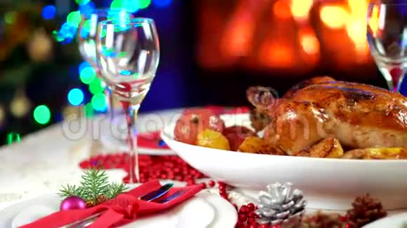 在壁炉前的圣诞桌上烤鸡还有带灯光的树视频的预览图