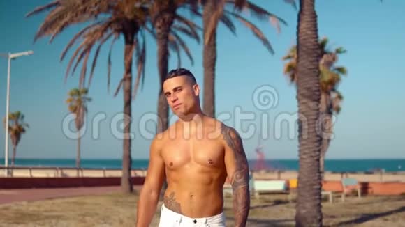 纹身健美性感男教练在海滩视频的预览图