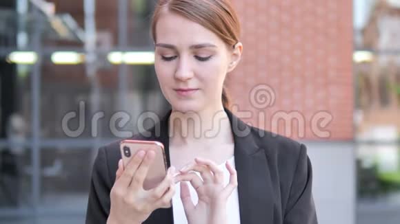 户外年轻女商人使用智能手机视频的预览图