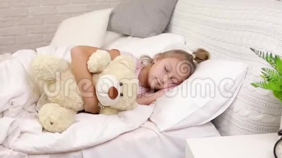 可爱的小女孩从床上醒来视频的预览图