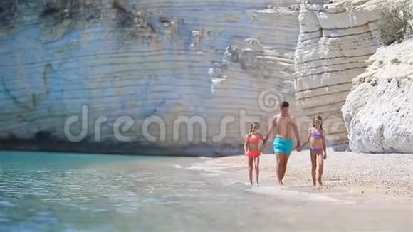 白色海滩上的爸爸和孩子们幸福的美丽家庭视频的预览图